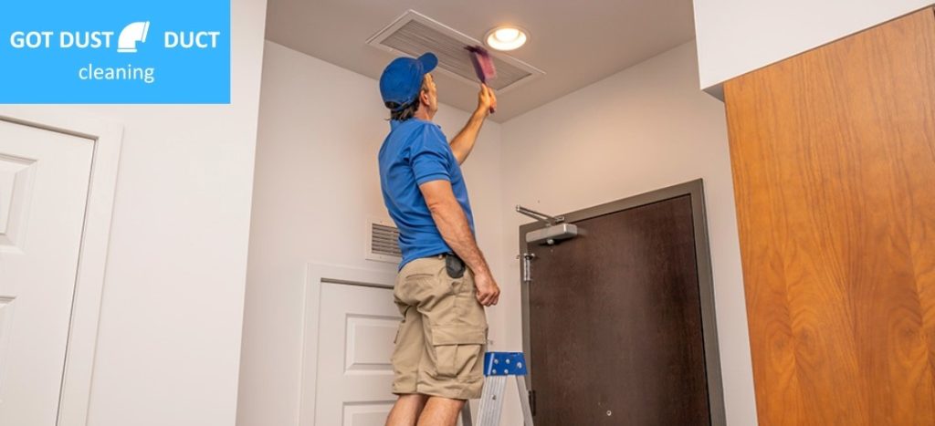 A man cleaning air duct